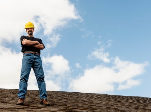 One of the Best Roofers in Clinton IL standing on a roof