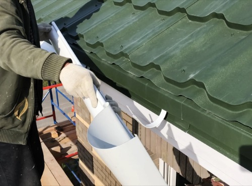 A contractor installing new Gutters in Champaign IL