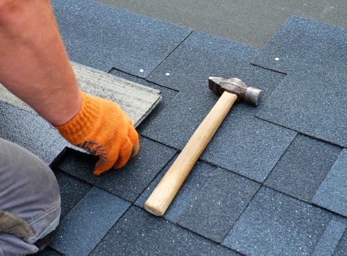 Roof Contractors for Fairbury IL nailing shingles to a roof