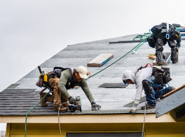 a team from Popejoy Roofing, a roofing company near me in Bloomington IL installs new shingles
