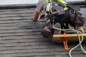 Roofers Near Me Bloomington IL 1 a member of Popejoy Roofing — "roofers near me" in Bloomington IL works on a roof
